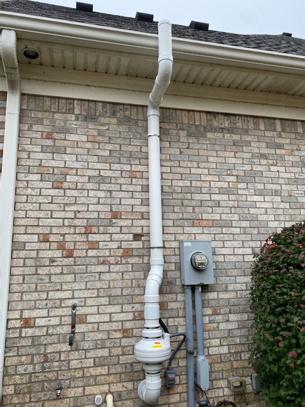 the side of a brick home with a water drain